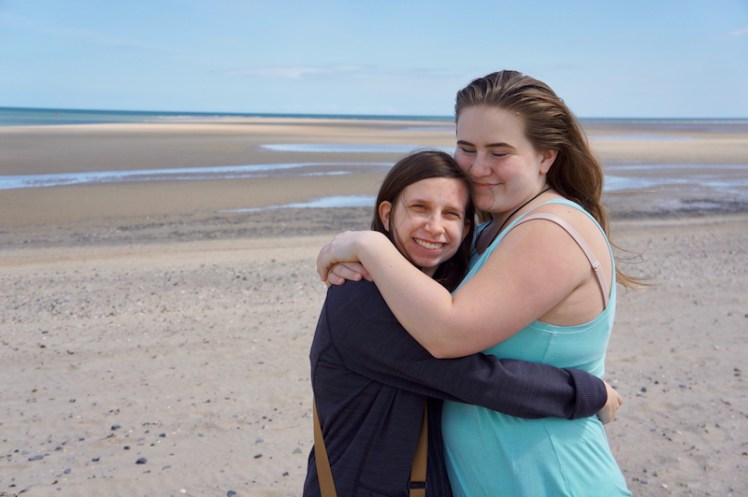Kenzie and Zoe are all hugs on the beach.